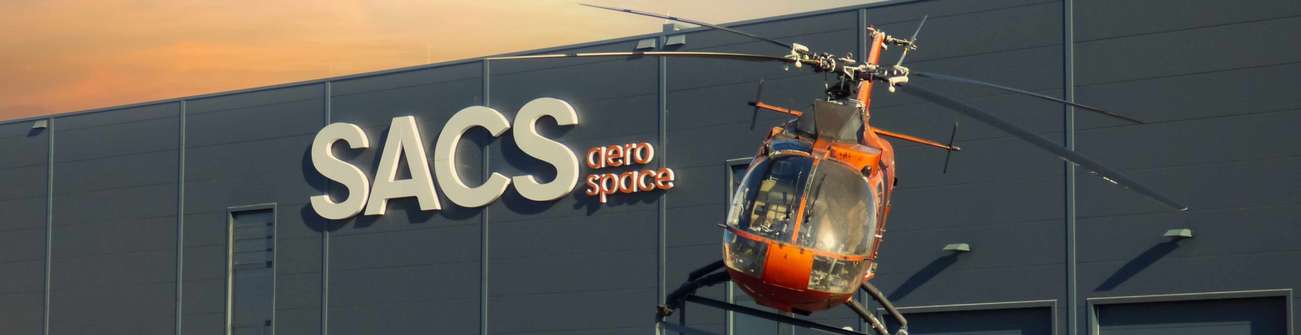 Anblick auf die Produktionshalle und Hubschrauber vor dem Gebäude.